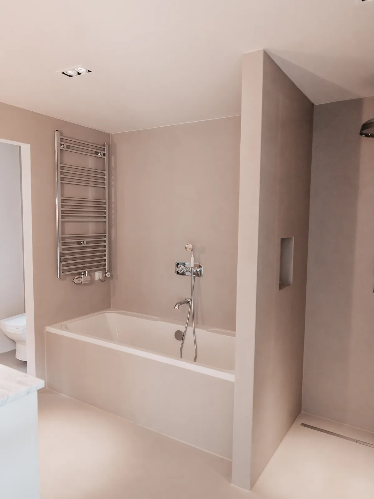 Nachher: fugenloses Bad mit Wanne und fugenloser Wand in hellem Ton