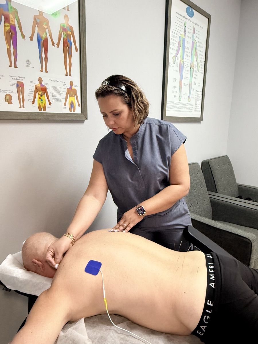 Dr. Zakia Chang placing needles along a patient’s back